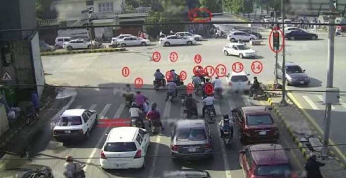 کراچی ٹریفک پولیس اہلکار ای چالان سسٹم کی نگرانی کرتے ہوئے، روڈ پر نصب کیمرے اور گاڑیاں۔