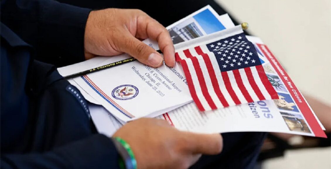 امریکی امیگریشن سروسز کے دفتر کے باہر بورڈ آویزاں ہے جبکہ دنیا کے مختلف ممالک کے شہری درخواستیں روکے جانے سے متاثر دکھائی دیتے ہیں۔